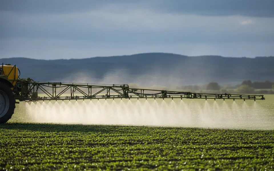 Boom sprayer applying a foliar spray across a field crop, the delivery method for 5 micron seabird guano powder