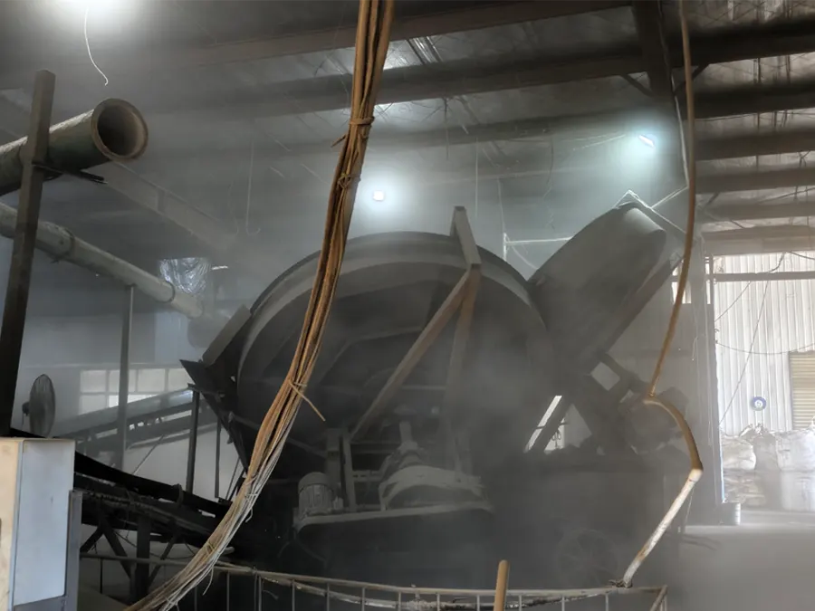 Pan granulator turning seabird guano powder, bentonite binder and water into 2 to 4 mm granules